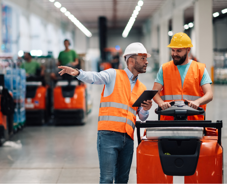 A safety Officer and a plant worker completing a forklift audit at a warehouse through Safety Champion Software on a tablet